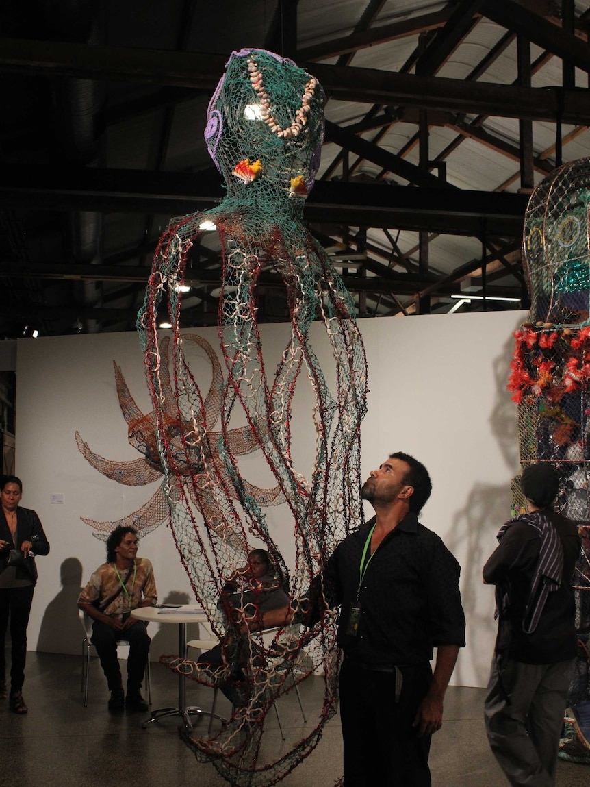 Steven Kepper looks up at his giant octopus art, created with recycled materials from the Great Barrier Reef.