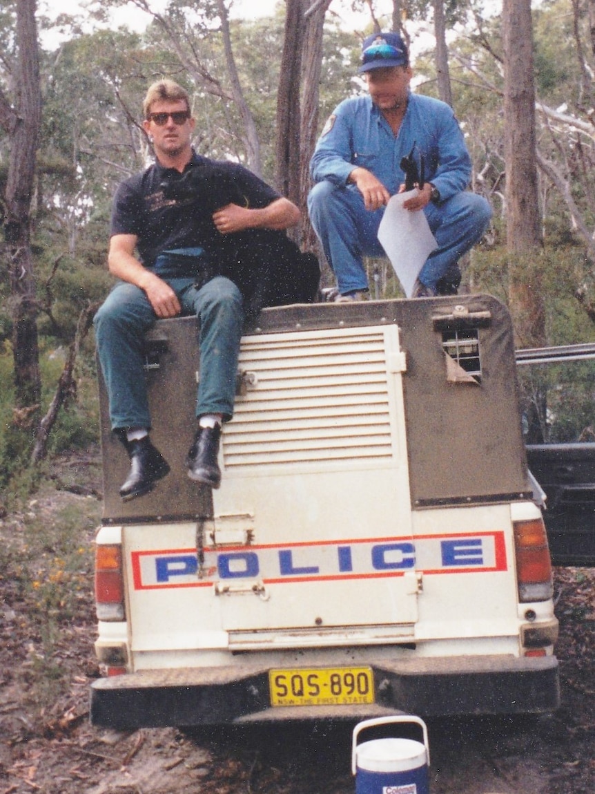 Craig Murray with dog and NSW Police officer sitting on top of police car.