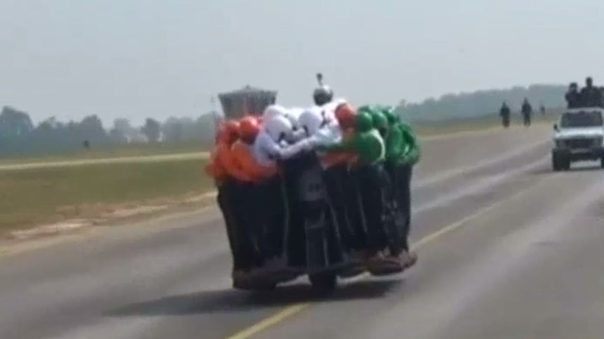 58 men balance on moving motorbike