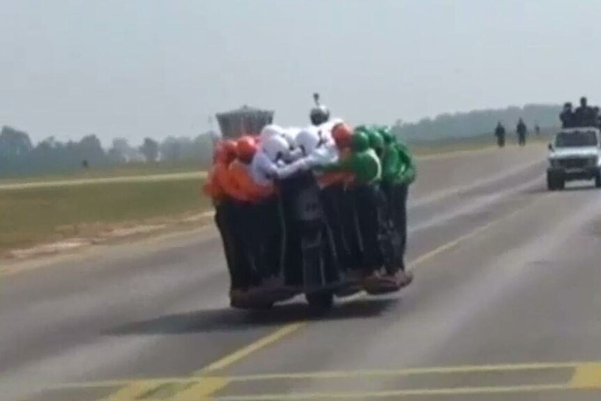 58 men balance on moving motorbike