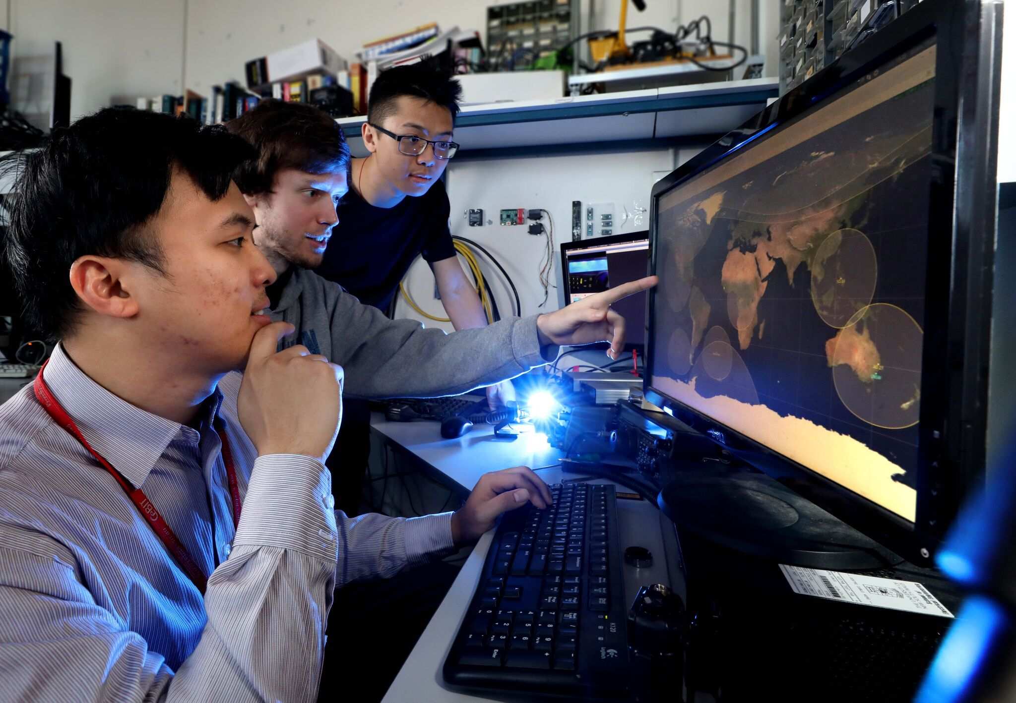 Three engineers looking at a computer.