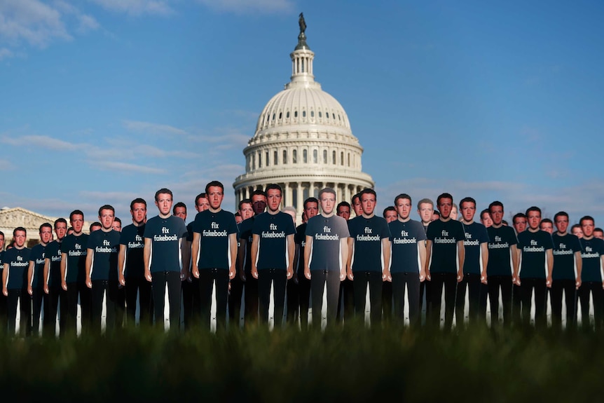 Life-sized cut-outs of Mark Zuckerberg in front of Capitol building.