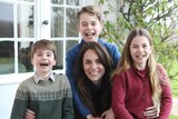 Image of Princess Kate and her three kids smiling into the camera.