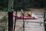 Swift water rescue teams on a boat in floodwaters.