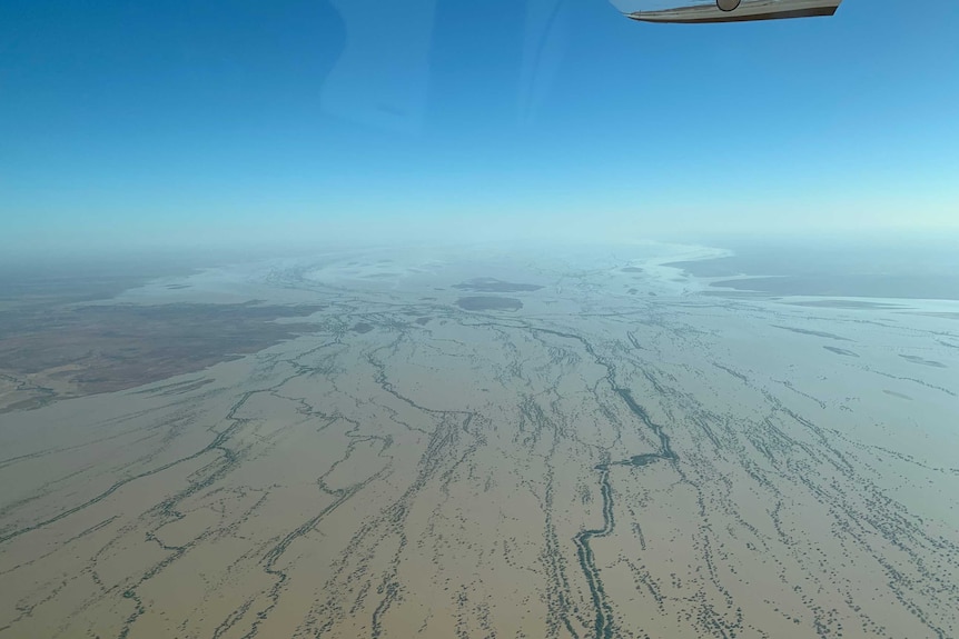 A large body of water moves through an outback landscape. The image is taken from the air.