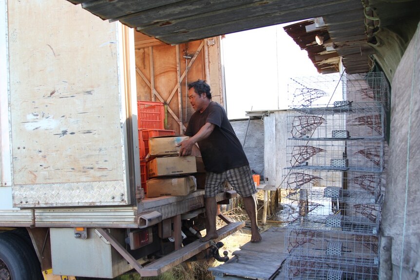 a man taking boxes out of a truck into a shack