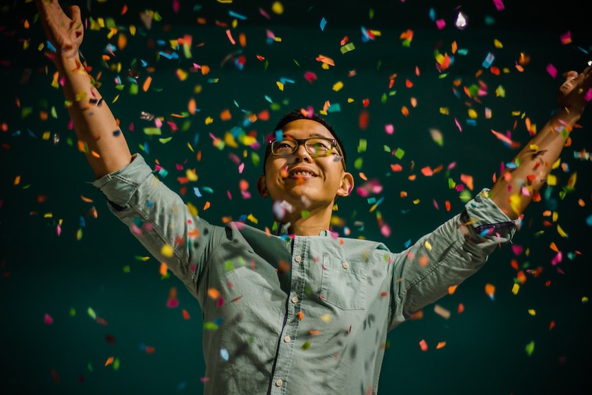 Smiling man surrounded by falling confetti, depicting the relief of successfully moving to a more suitable bank.