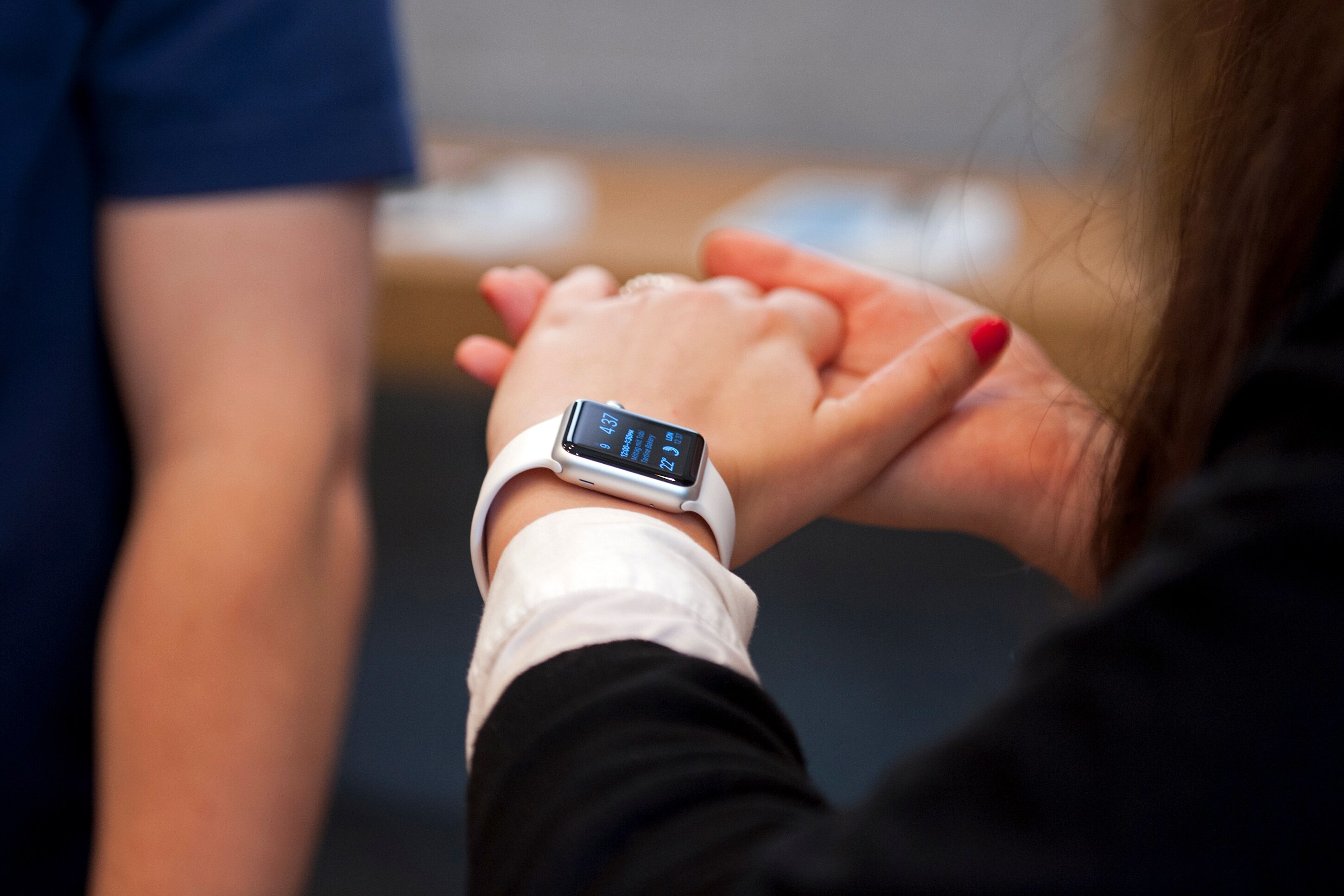 a woman's arm with an apple watch on it being inspected in a apple store