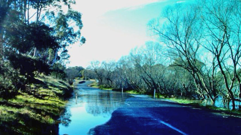 Water floods a road near Perth, Tasmania after heavy rain.