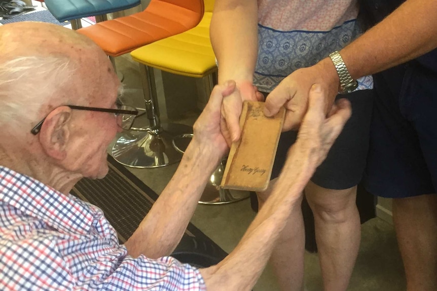 Andy Coates and Nicola Cleaver showing their grandfather his old bee keeping book.