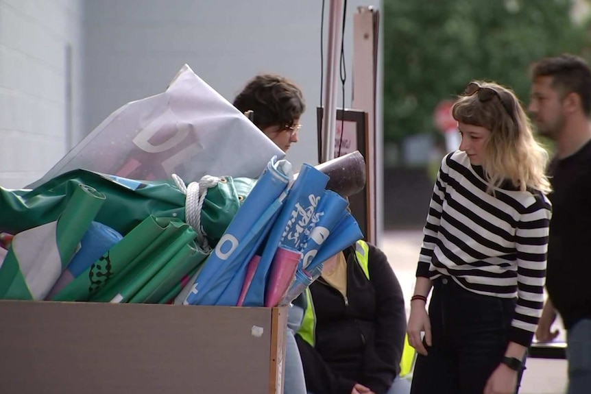 A woman looks at a bin full of banners