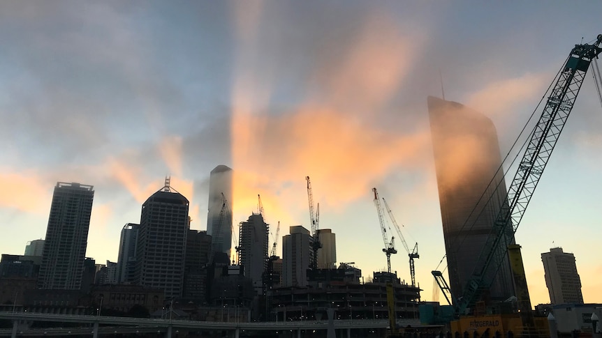Brisbane CBD skyline in silhouette as the sun rises behind