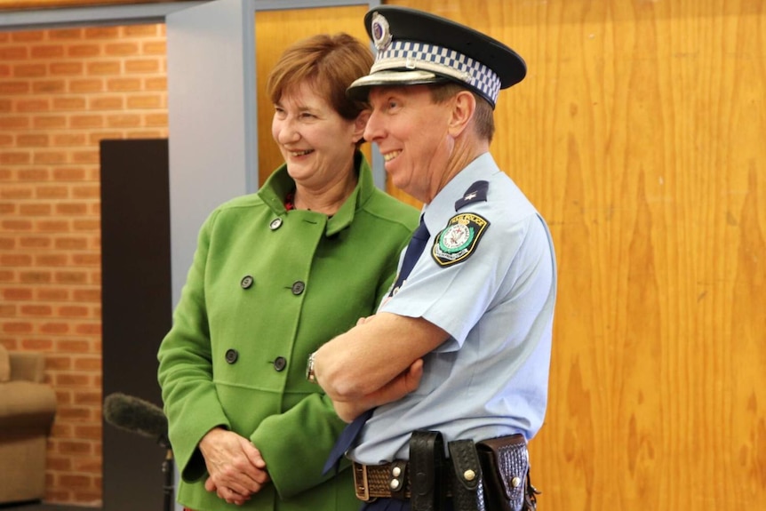 A woman and a man standing next to each other, smiling.