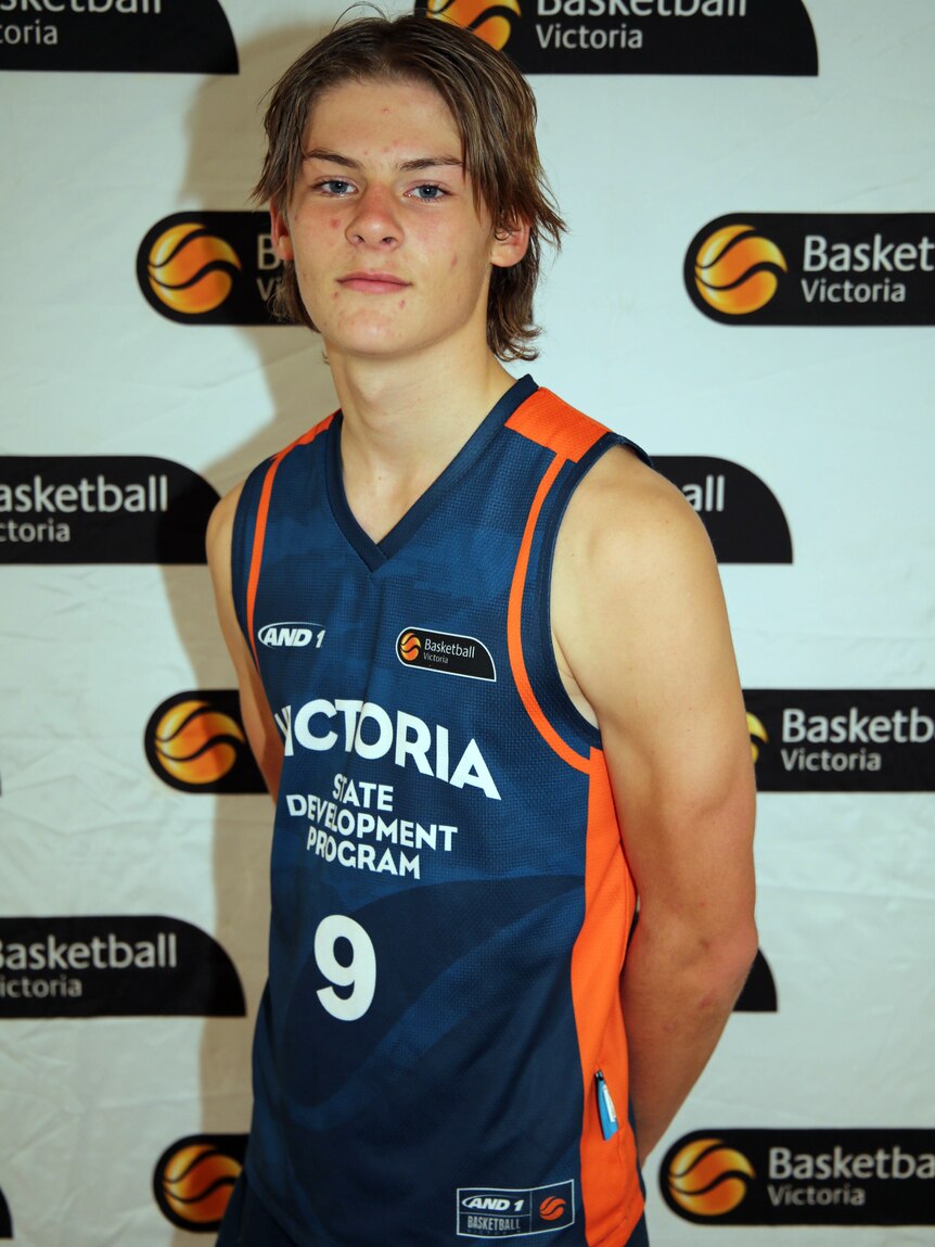 boy in basketball clothing looking at camera