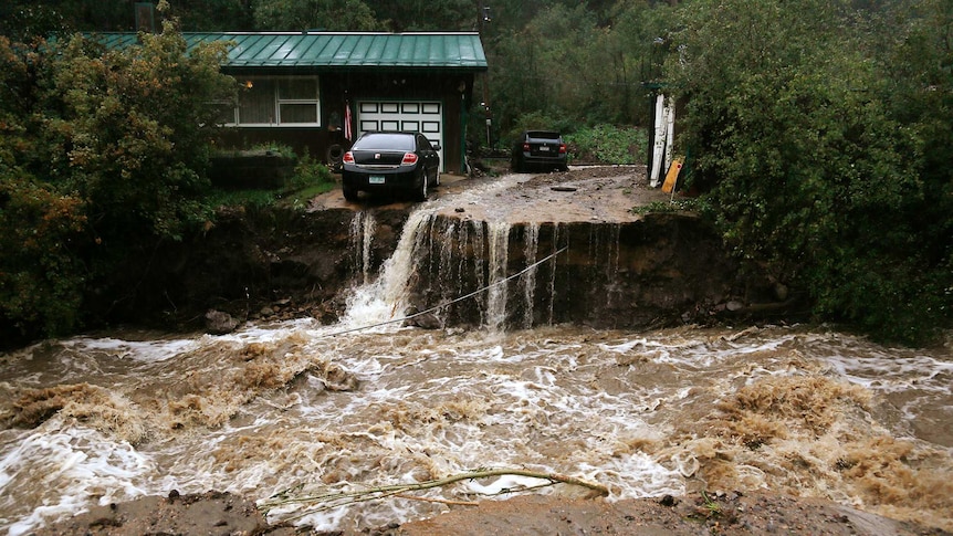 A home and car are stranded after a flash flood in Coal Creek destroyed the bridge near Golden, Colorado.