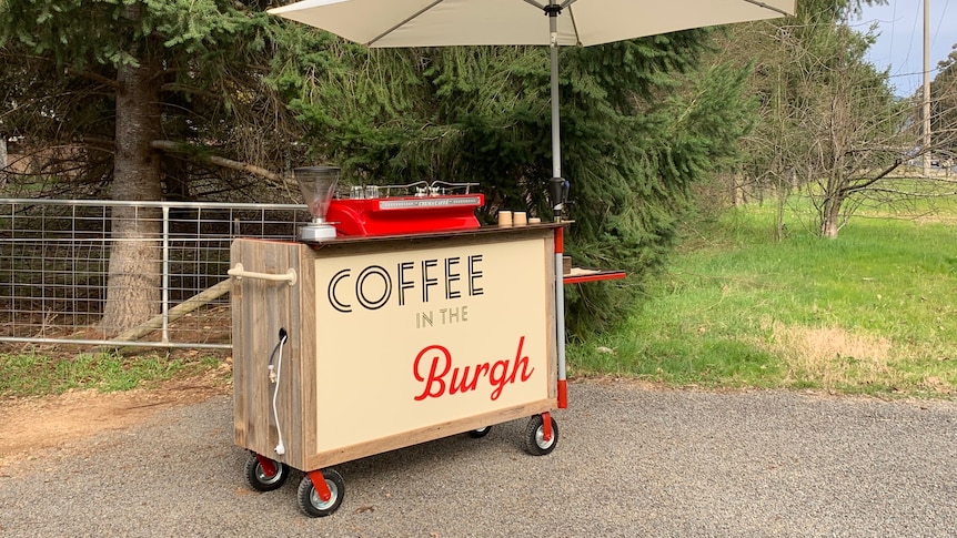 mobile cart with umbrella and red coffee machine