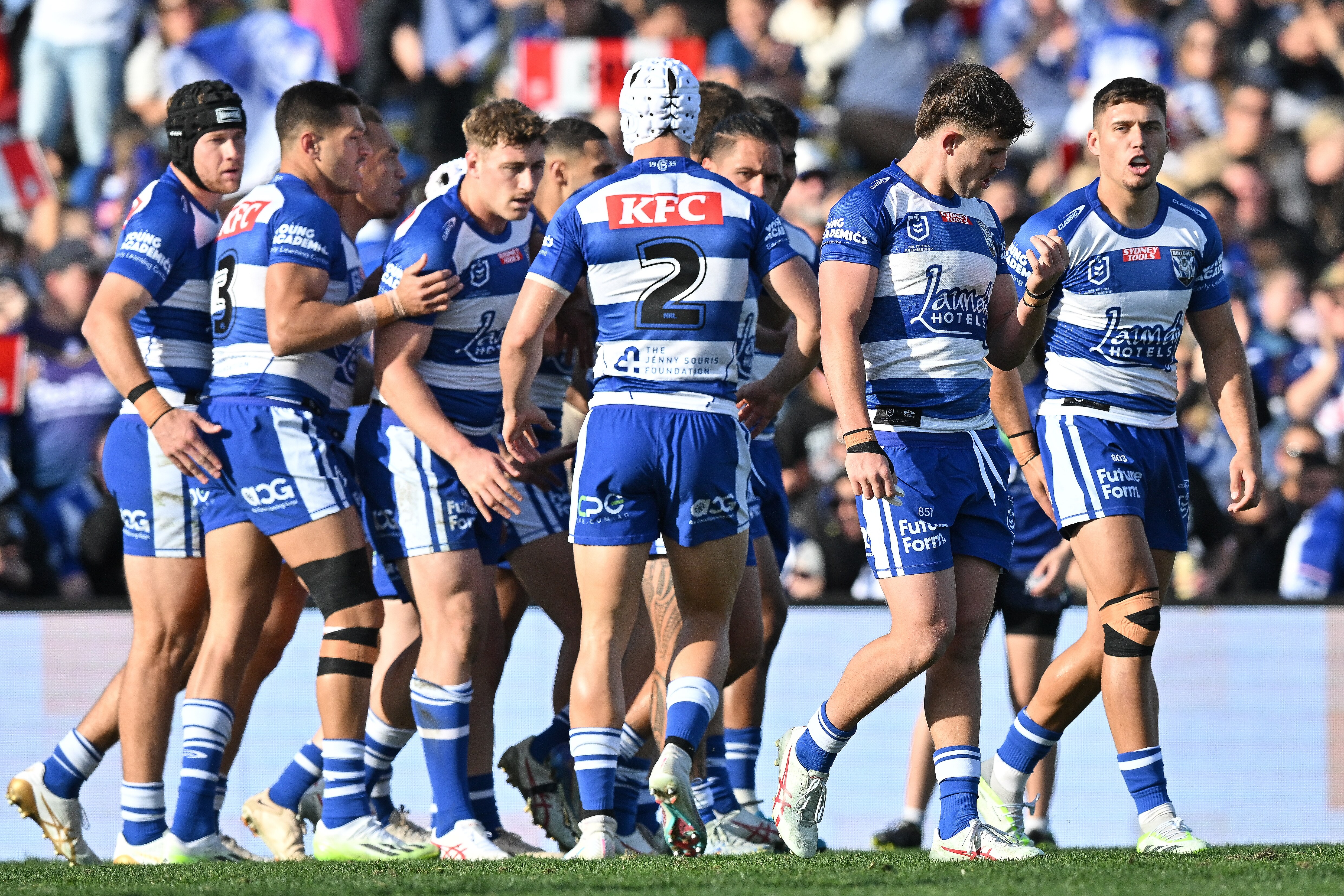 A group of rugby league players celebrate after scoring a try