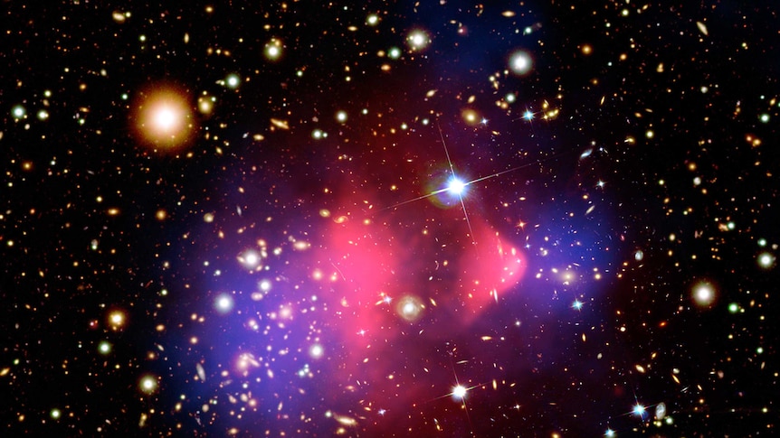 A composite image showing the bullet cluster of galaxies, with some overlay showing x-ray emissions andthe effects of dark mass.
