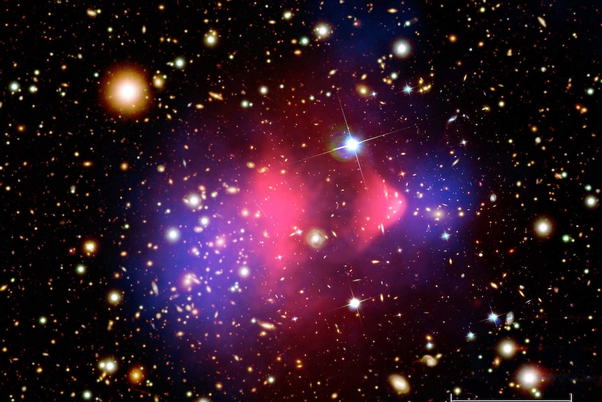 A composite image showing the bullet cluster of galaxies, with some overlay showing x-ray emissions andthe effects of dark mass.