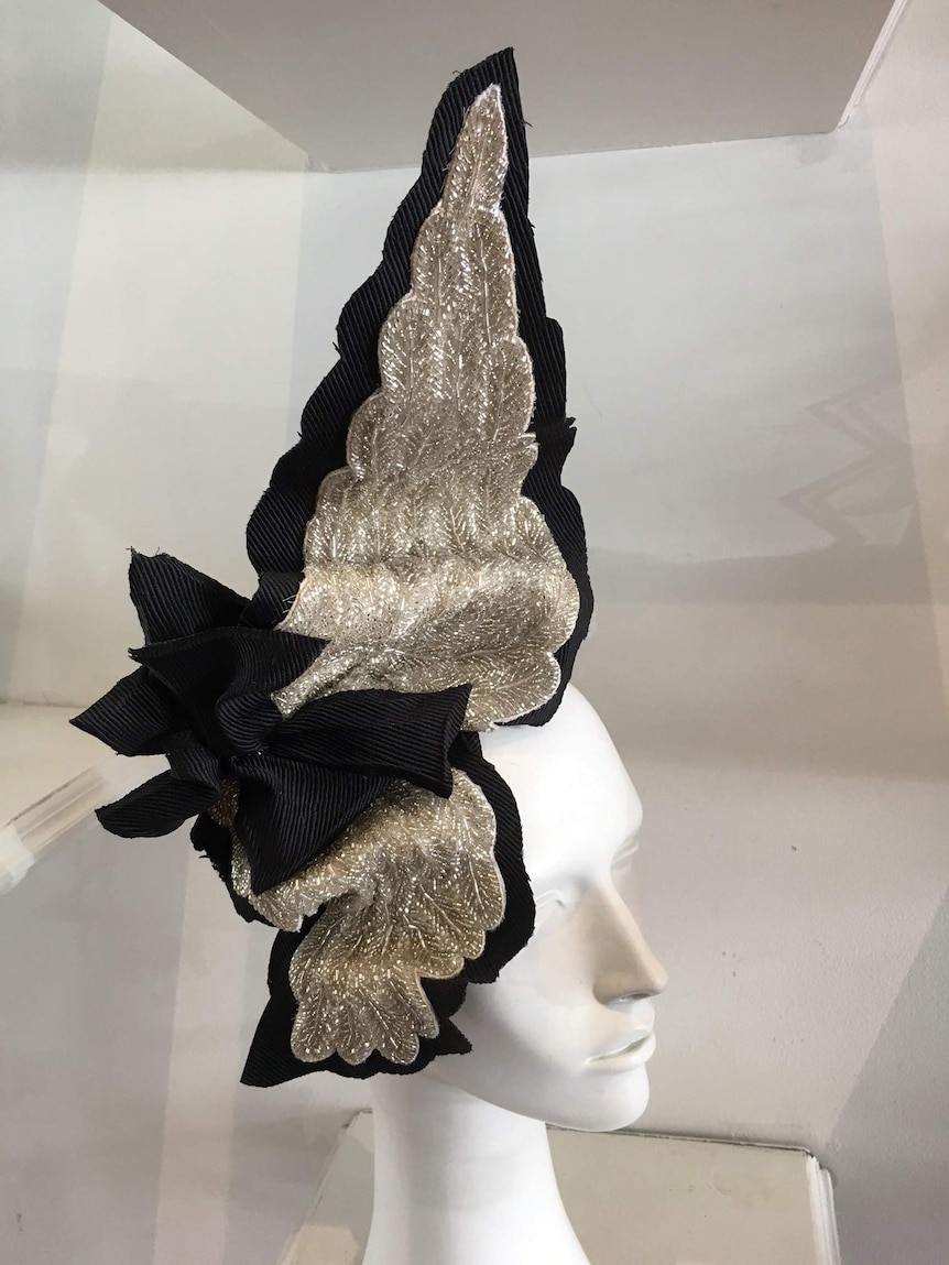 A silver and black fascinator on a head bust