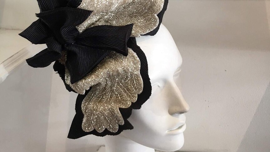 A silver and black fascinator on a head bust