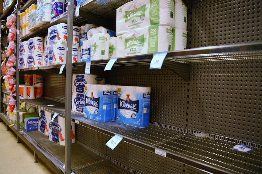 Half-empty shelves of toilet paper at Darlinghurst IGA.
