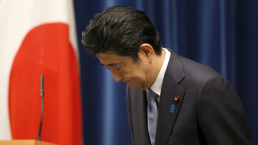 Japan's prime minister Shinzo Abe bows as he leaves a news conference