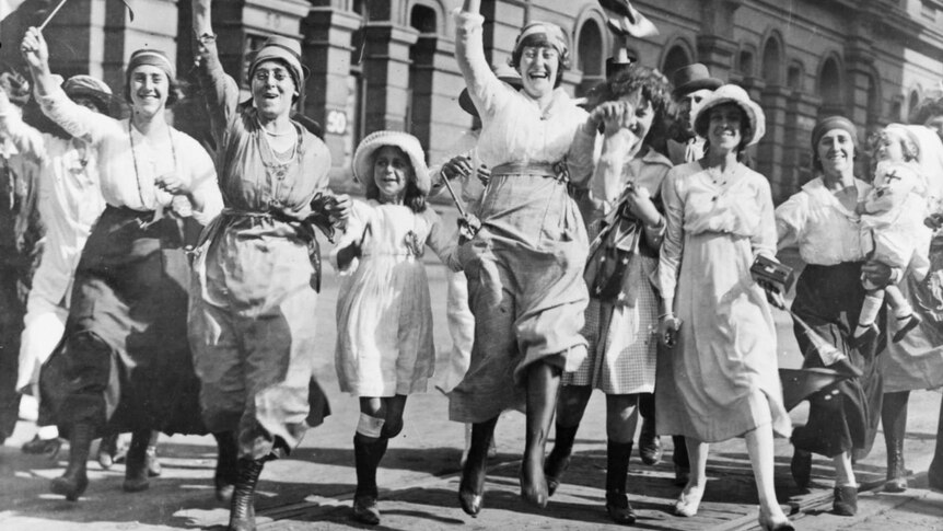 A group of women and children rejoicing in a street in Sydney at the signing of the Armistice.