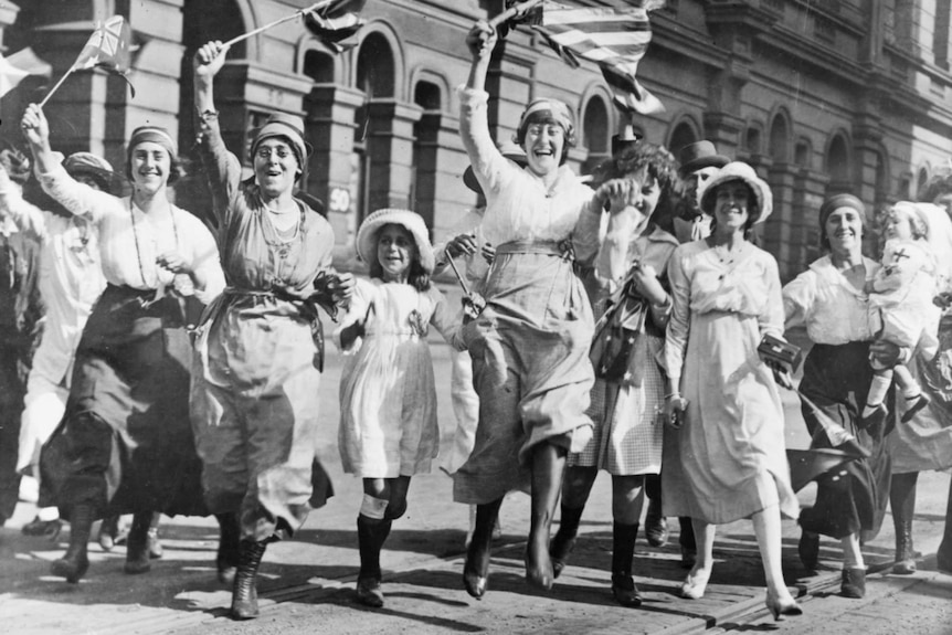 A group of women and children rejoicing in a street in Sydney at the signing of the Armistice.