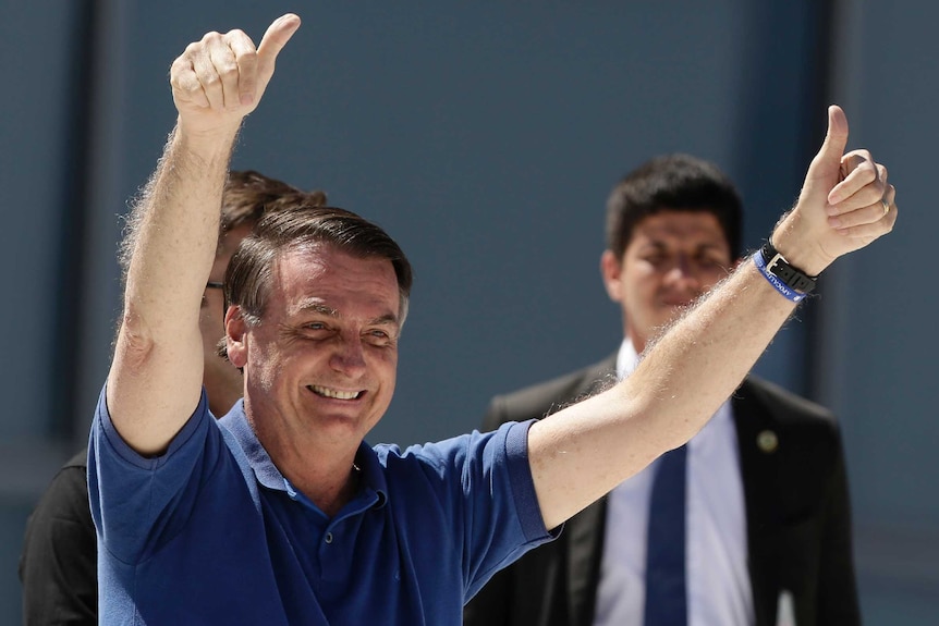 Jair Bolsonaro gives a thumbs up with a wide smile on his face