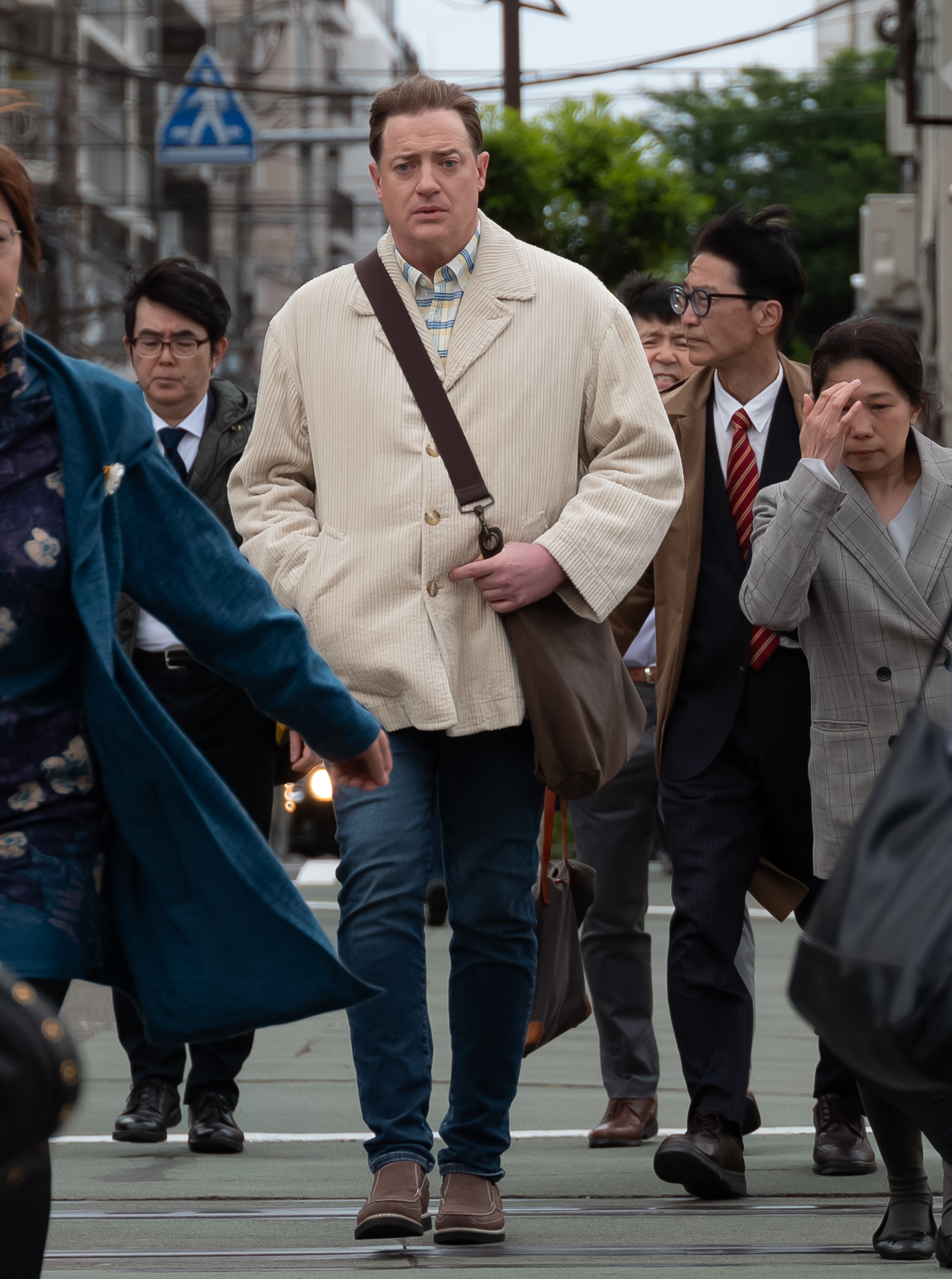 Un hombre alto camina entre la multitud.