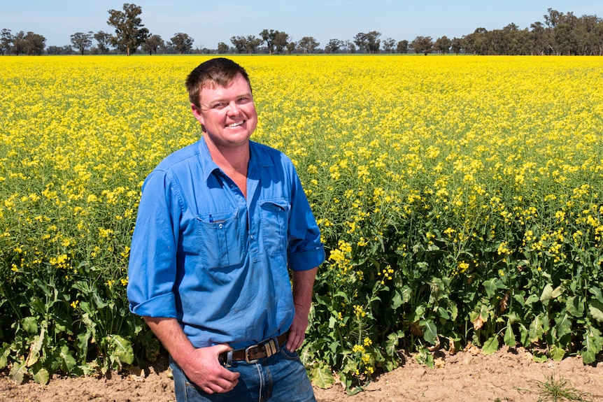 Tom Green standing in front of canola field.