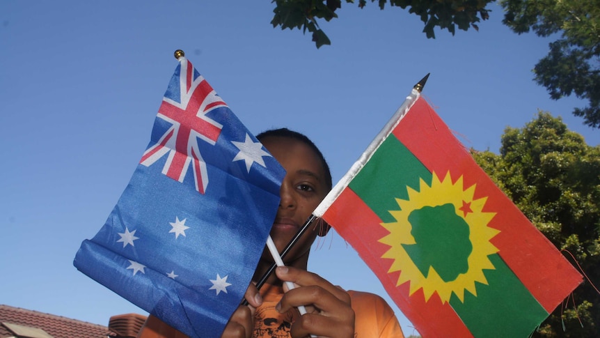 10-year-old Bonsen Wakjira raises two flags on Australia Day