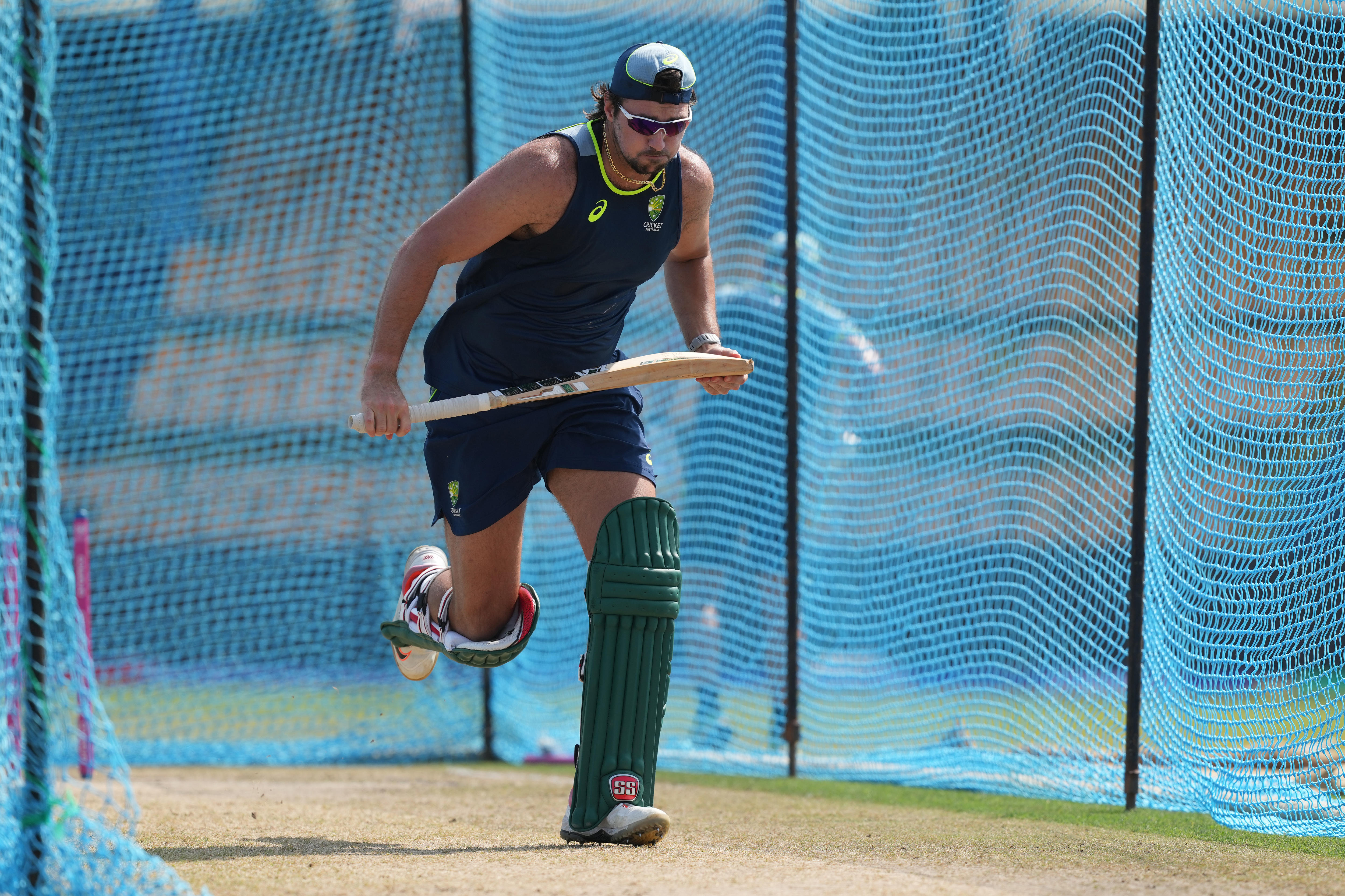 Australia batter Tim David running while holding a bat and wearing a singlet at training before the T20 World Cup.