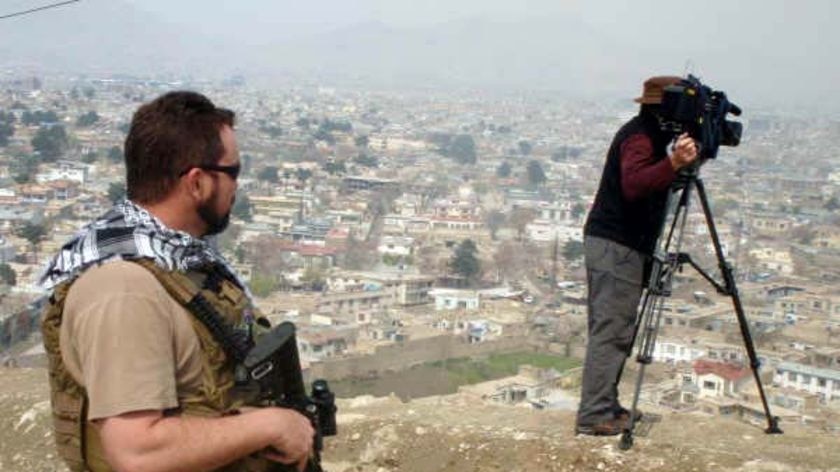 'Scotty', who was in charge of Foreign Correspondent's security detail, keeps an eye out for cameraman Michael Cox as he films in Nangarhar Province.