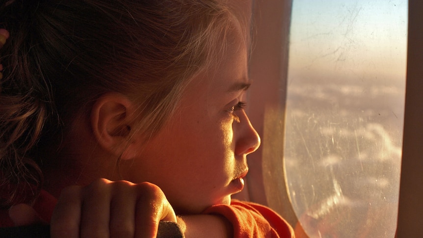 A young girl looking out of a window.