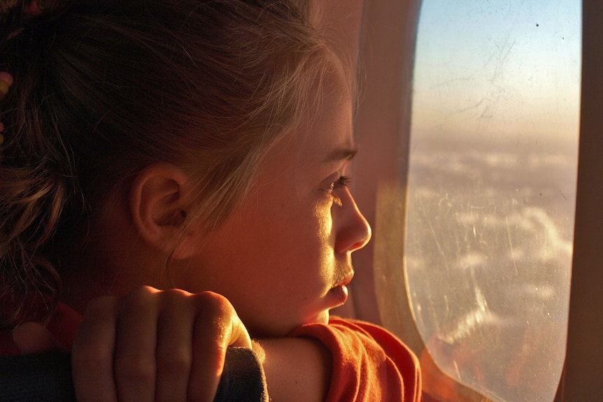 A young girl looking out of a window.