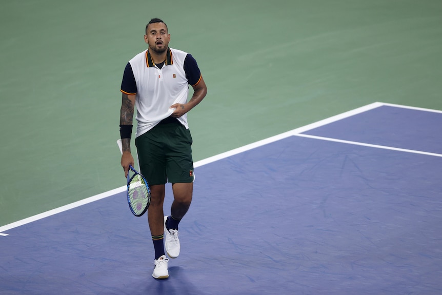 Tennis player walking off, looking disappointed after losing match