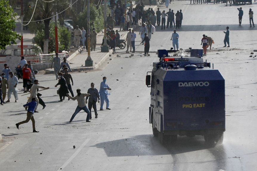 Supporter of Pakistan's former Prime Minister Imran Khan throw stones at a police vehicle during a protest.