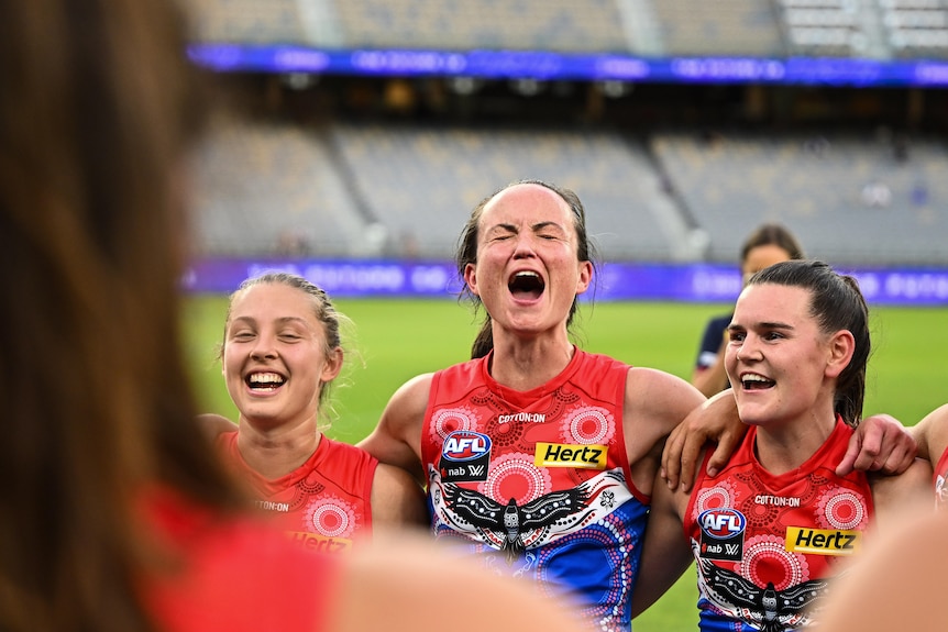 Daisy Pearce of the Demons strains joyously while singing the team song after a win during the 2022 AFLW season
