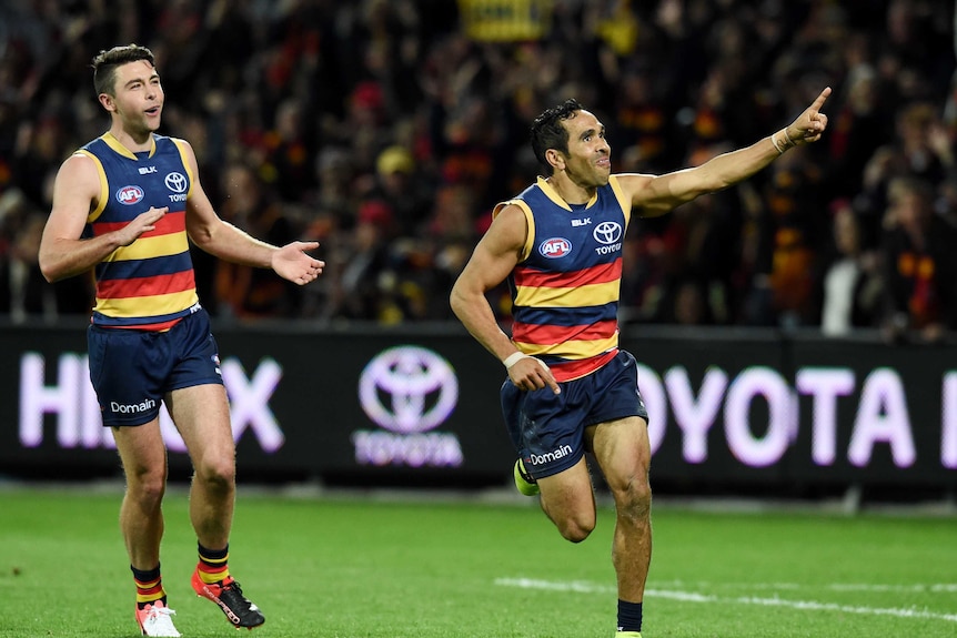 Two Crows players celebrate after scoring.