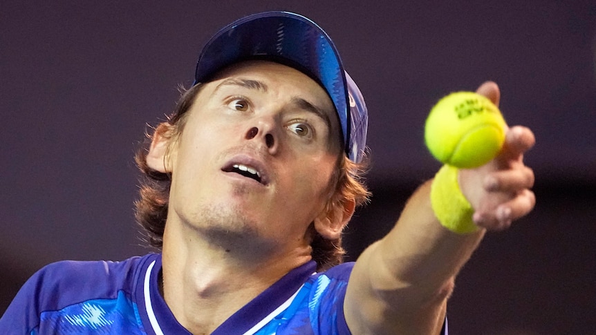 Alex de Minaur throws a tennis ball into the air while playing in the Paris Masters.