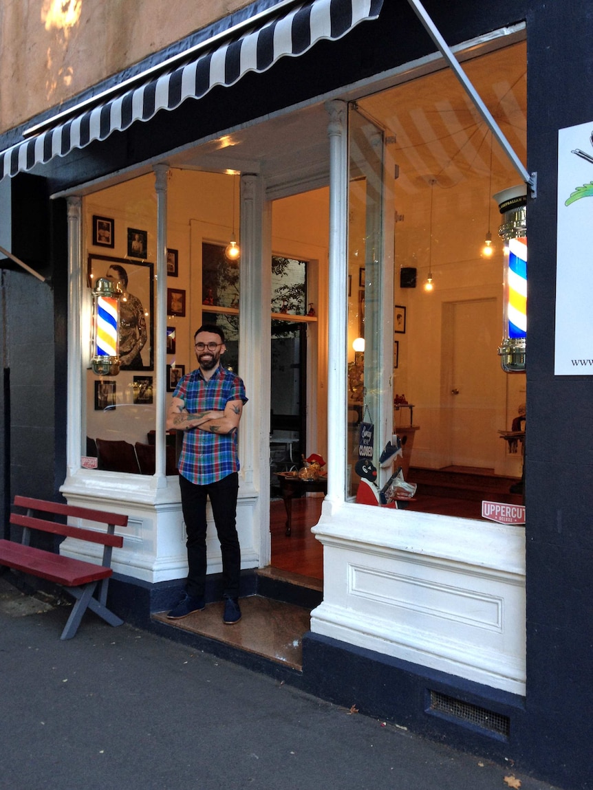 Nathan Meers stands in front of the Happy Sailors barber shop.
