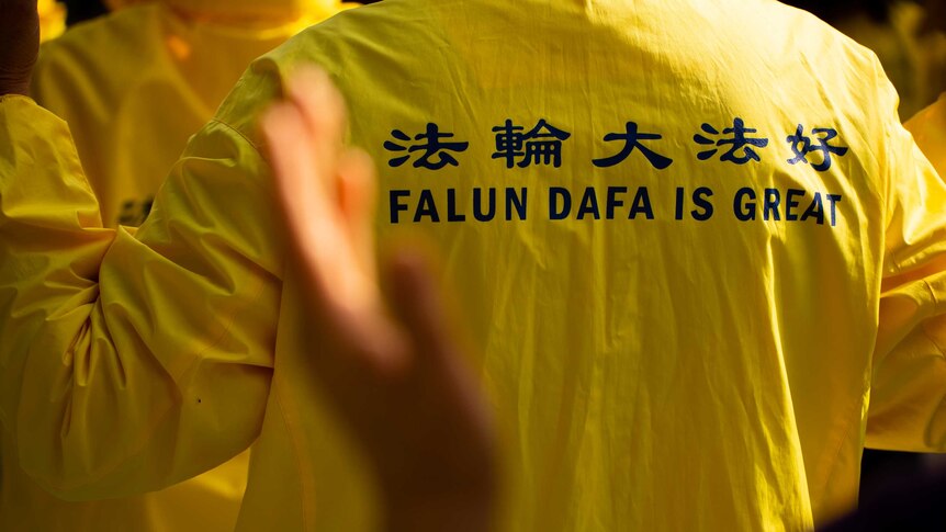 A Falun Gong practitioner wears a yellow jumper.