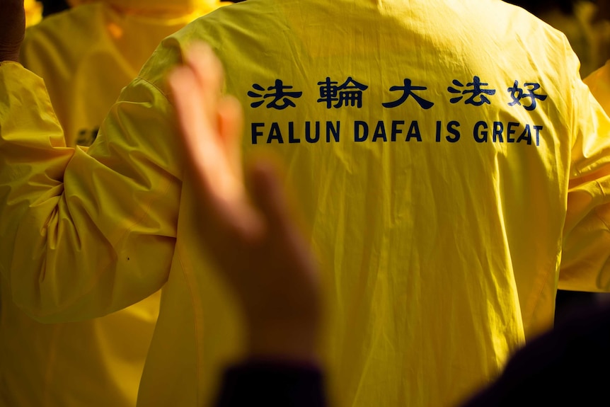 A Falun Gong practitioner wears a yellow jumper.