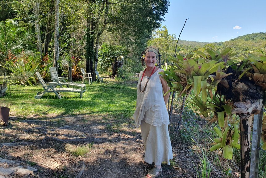 Lady standing in her garden with two lounge chairs behind her