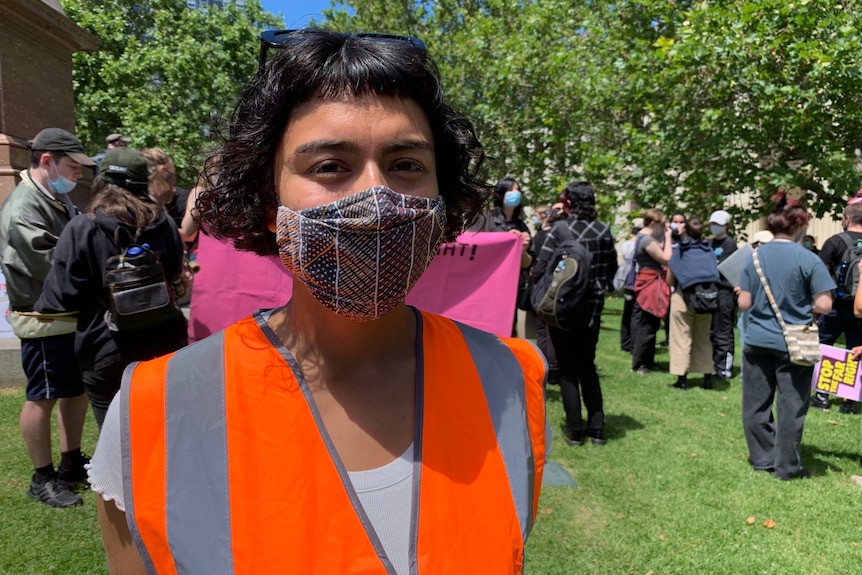 Nahui Jimenez wearing an orange high-vis vest and mask.