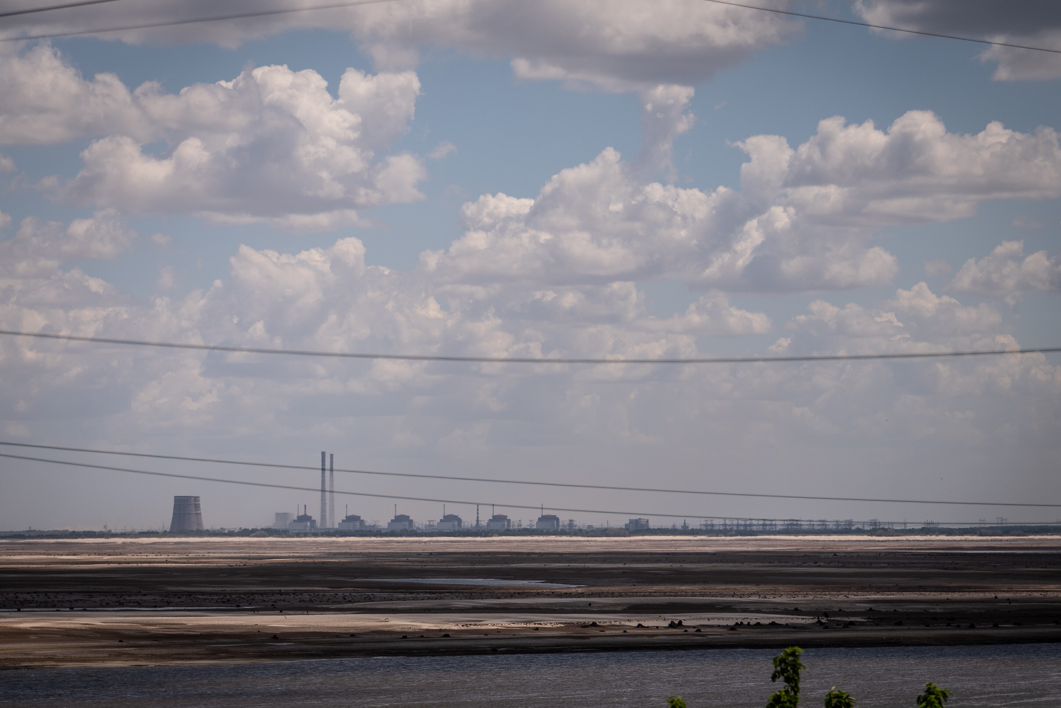 A nuclear reactor and other tall buildings are visible on a hazy horizon