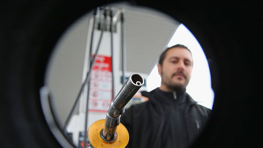 A man refuels his car at a petrol station.