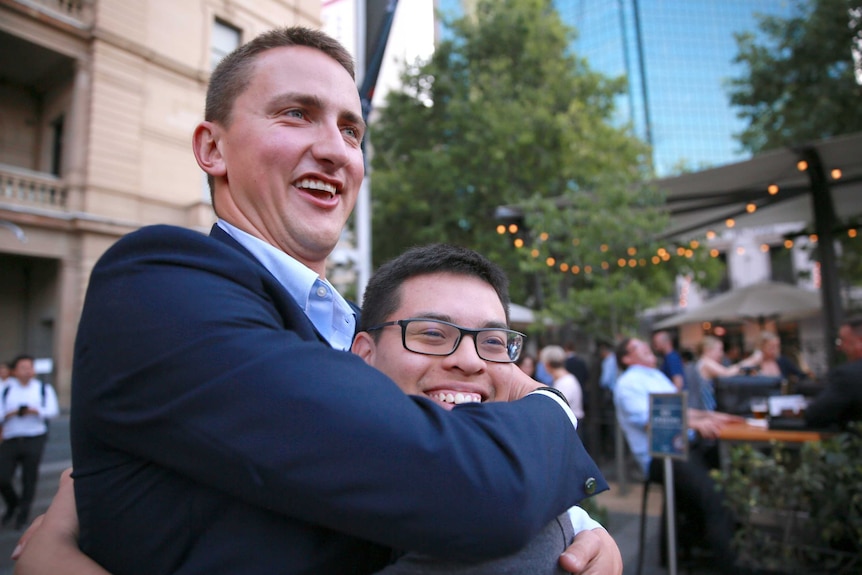 David Lawrence-Watt hugs Will Curtis at a restaurant.